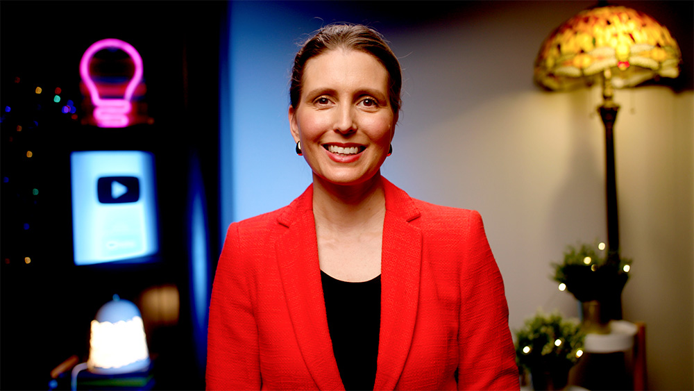 Kara Ronin smiling wearing red jacket.